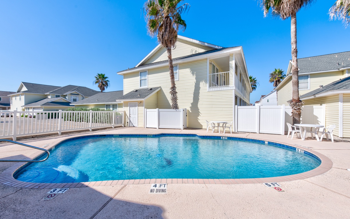 Take a refreshing dip in the community pool, surrounded by swaying palm trees and sunny skies in this peaceful coastal retreat.