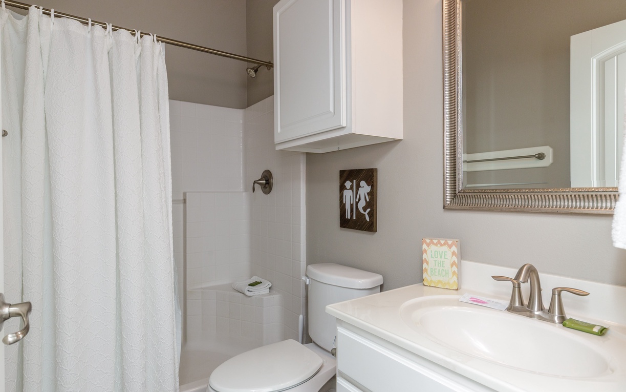 Your private bathroom features a relaxing tub-shower combo with crisp white finishes and thoughtful storage above the toilet.