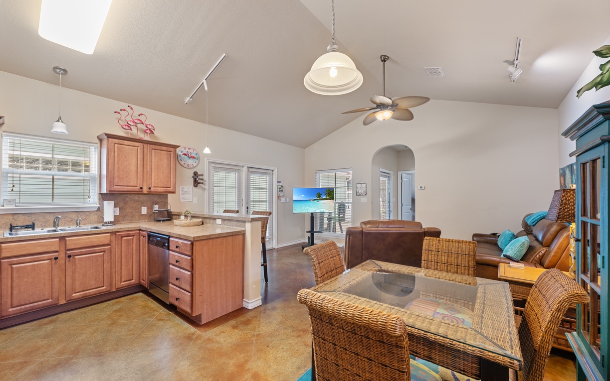Your open-concept living space blends coastal charm with modern comfort, featuring a full kitchen and dining area for memorable meals.