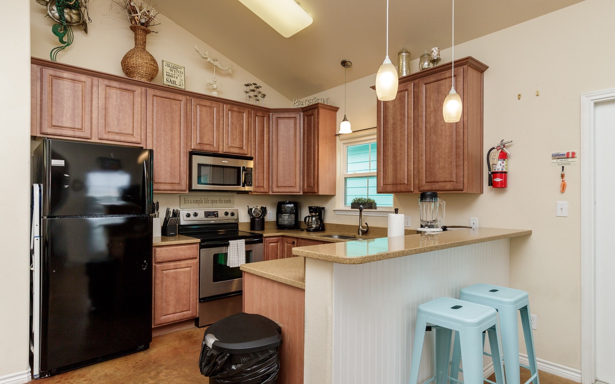 Your fully equipped kitchen features warm wood cabinets, modern appliances, and a breakfast bar where you can sip morning coffee.
