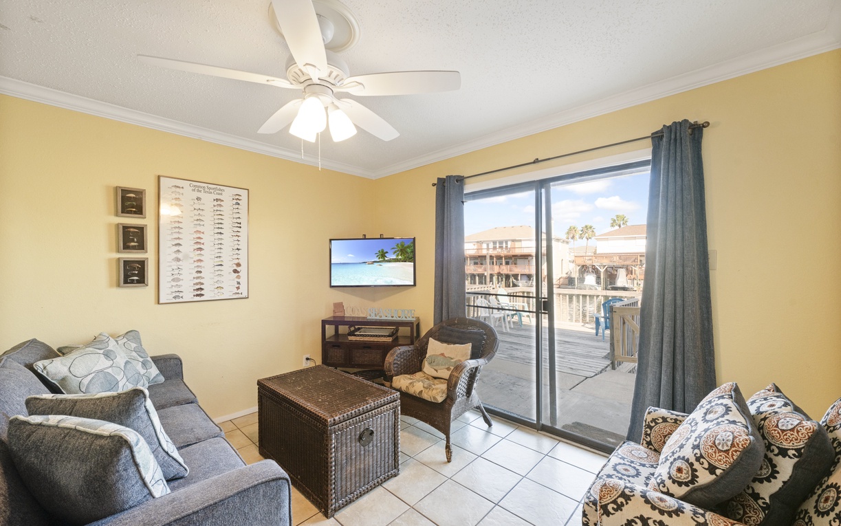 Unwind in your comfortable living room with coastal views, ceiling fan, and sliding door access to your private balcony.