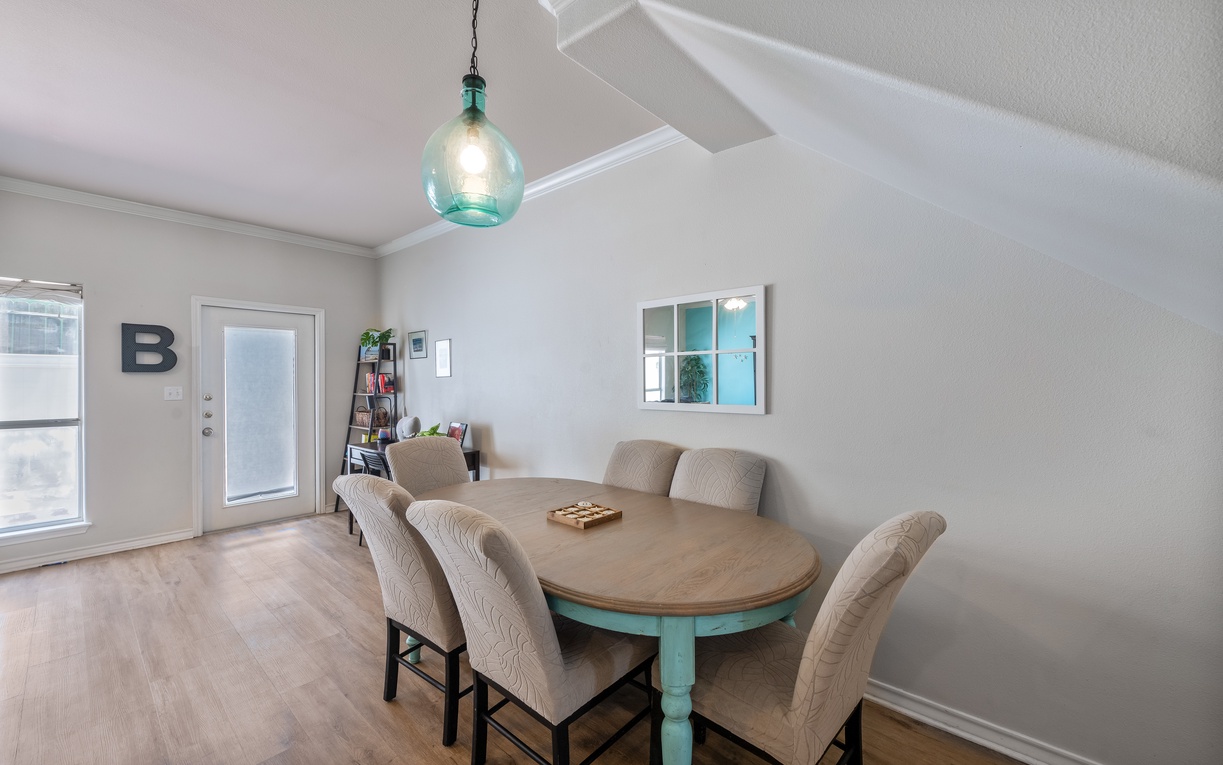Gather around your spacious dining table for memorable meals under the charming turquoise pendant light.
