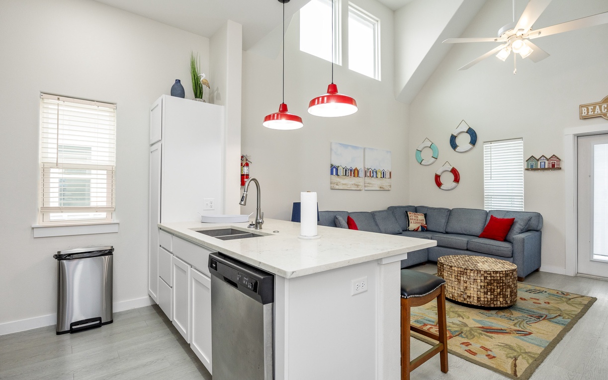 Your bright beach-themed haven features a modern kitchen island perfect for morning coffee and an inviting living space with coastal charm.