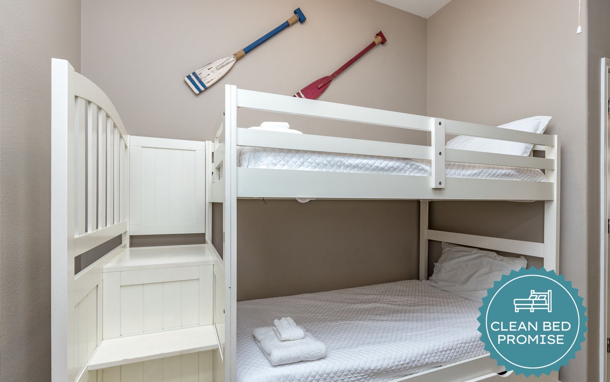 Your cozy bunk bed awaits with crisp white linens and nautical charm, perfect for adventurous nights.