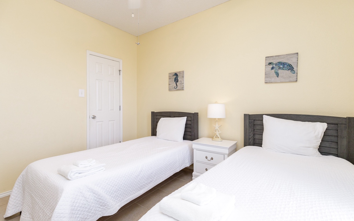 Rest peacefully in your bright twin bedroom, complete with fresh linens and charming coastal artwork for a perfect night's sleep.