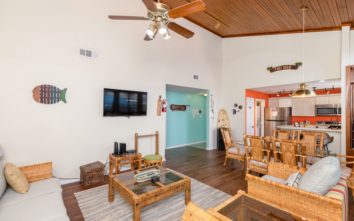Relax in your tropical-themed living space with wicker furniture, ceiling fans, and beach-inspired decor creating the perfect coastal retreat.
