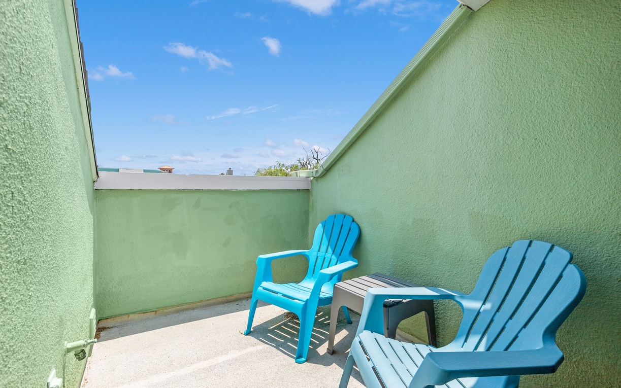 Step out to your private terrace where bright blue chairs await under open skies—perfect for morning coffee or evening relaxation.