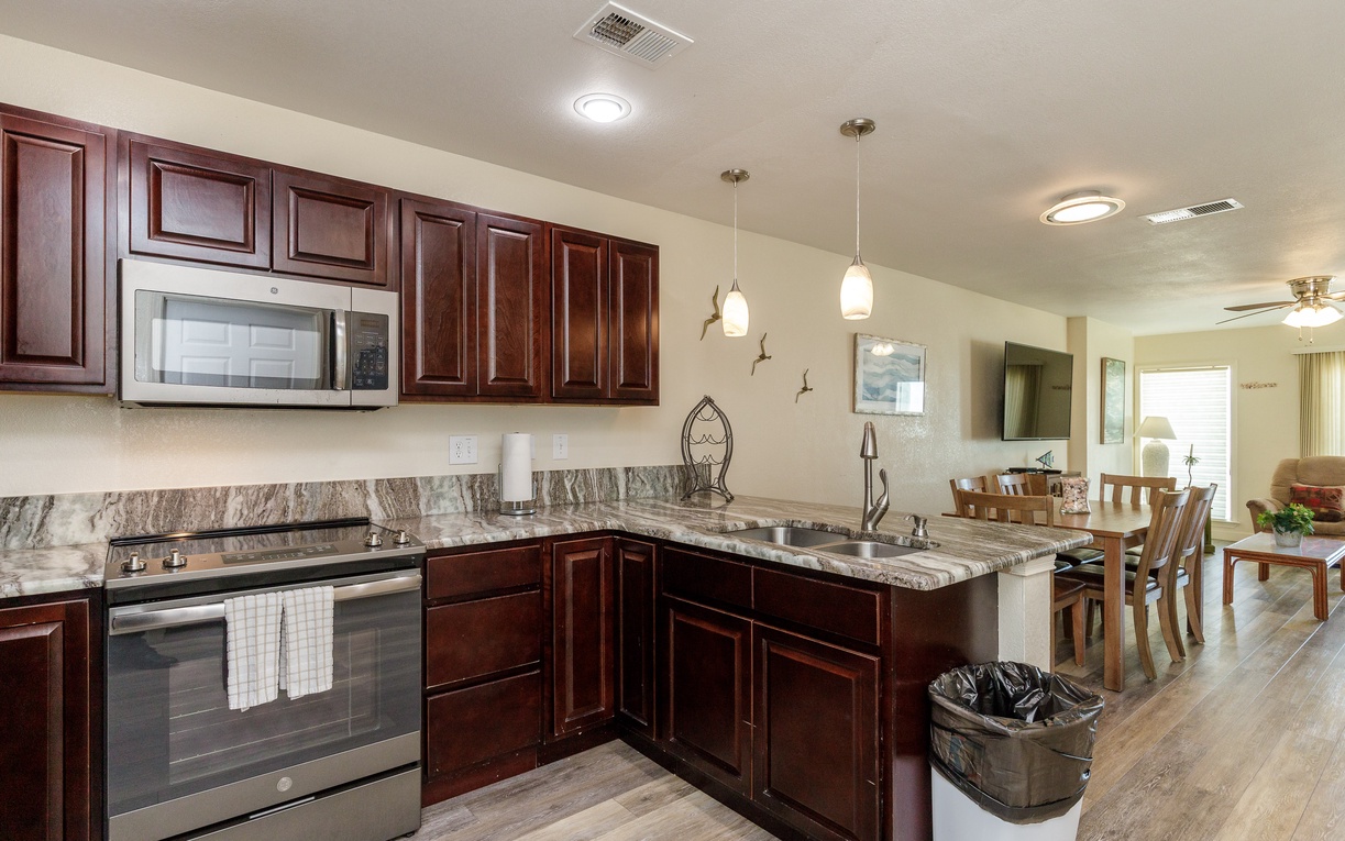 Your fully-equipped kitchen features elegant granite countertops, rich cherry cabinets, and stainless steel appliances, perfect for preparing memorable meals during your stay.