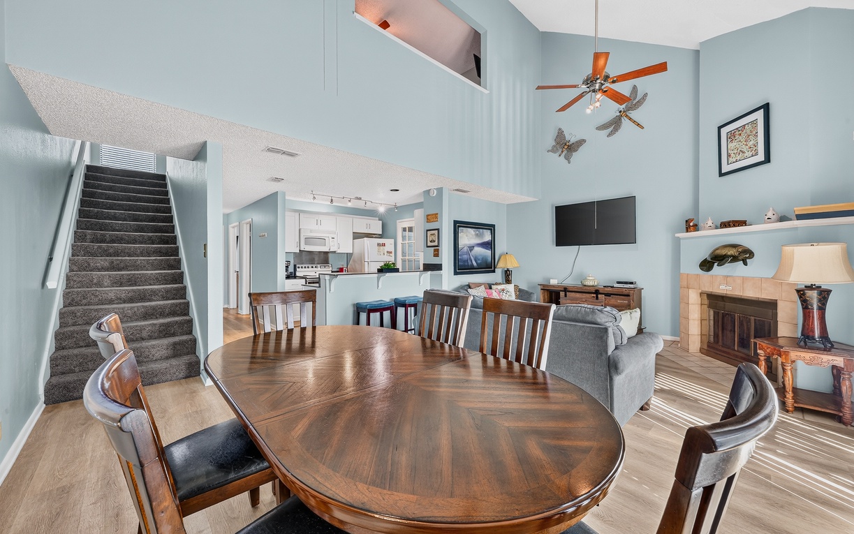 Gather around your spacious dining table in this bright, open living space with soaring ceilings and coastal charm, where the kitchen and cozy lounge invite you to relax and reconnect.