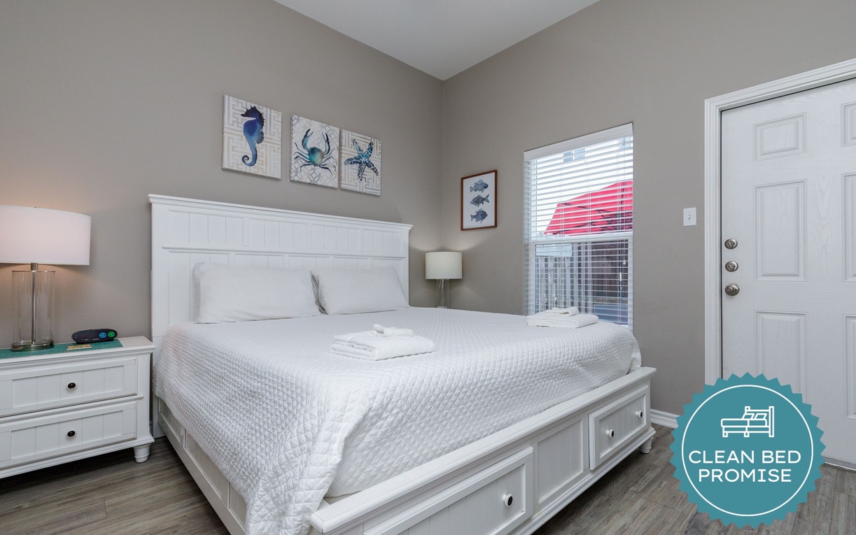 Sink into crisp white linens and coastal charm. Your peaceful bedroom features ocean-themed art and plenty of storage space.