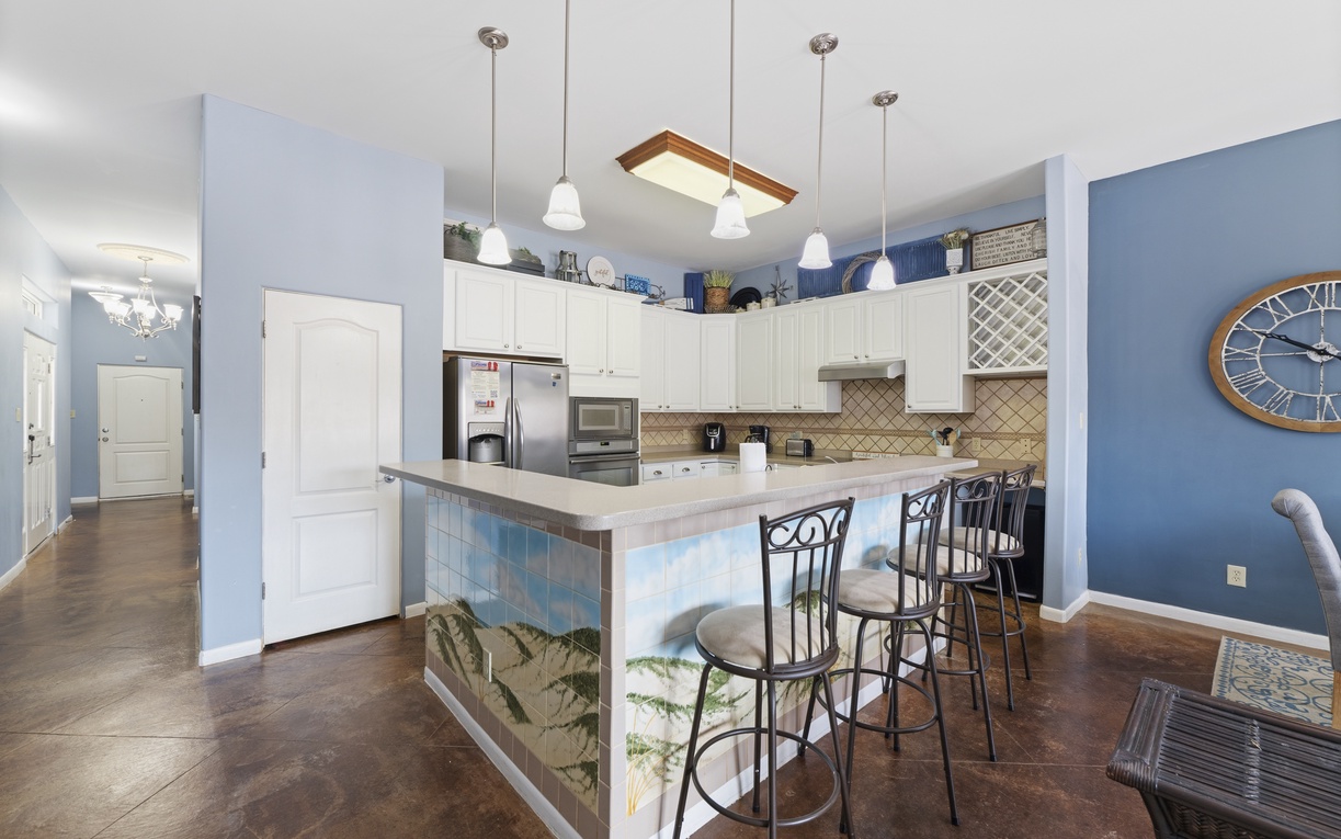Your fully equipped kitchen and island bar await with modern appliances, coastal charm, and plenty of space for cooking and gathering with loved ones.