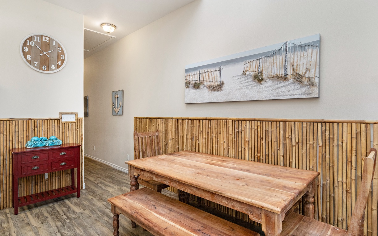 Unwind in your coastal-themed dining area featuring warm bamboo walls and beach artwork that brings the ocean indoors.
