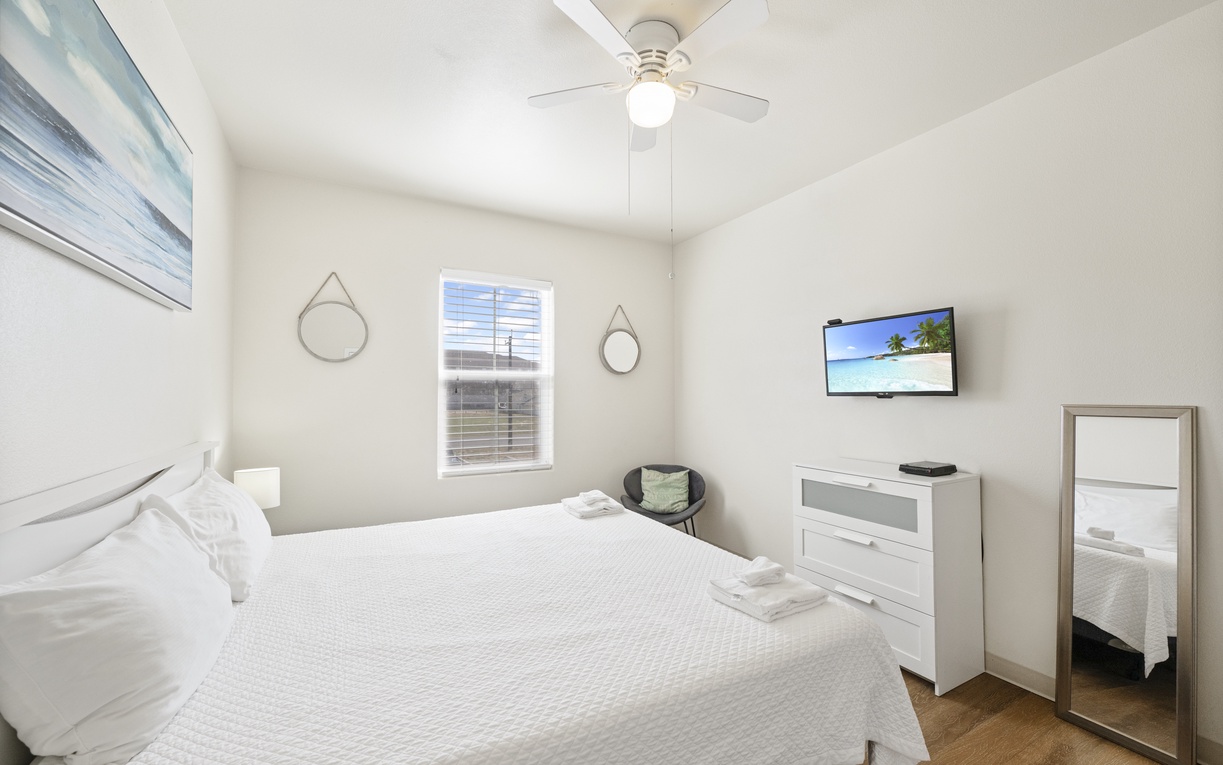 Rest peacefully in your bright, serene bedroom with crisp linens, modern amenities, and coastal artwork creating the perfect retreat.