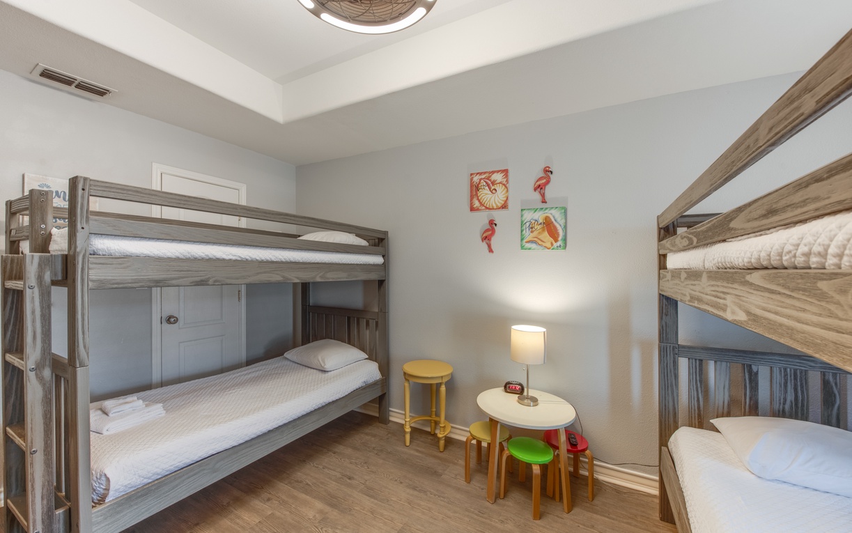 Your kids will love this cheerful bunk room with cozy beds and their own play table for games and activities.
