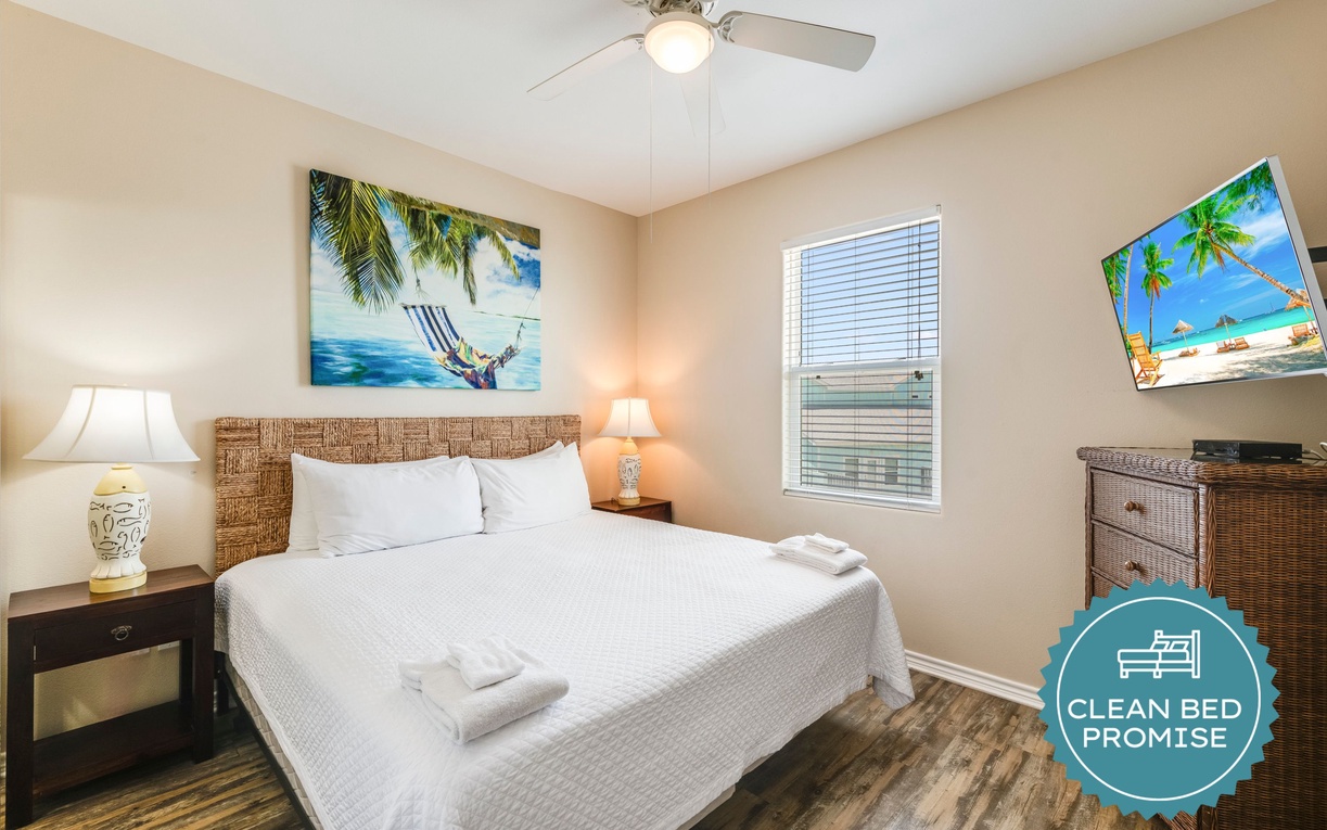 Drift off to sleep in your tropical-themed bedroom, where beach artwork and cozy wicker furnishings create a peaceful island retreat.
