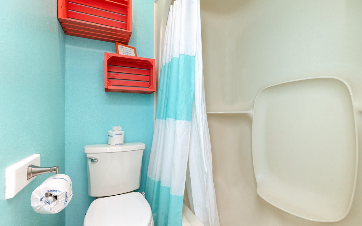 Step into your bright, cheerful bathroom with vibrant turquoise walls and fresh white fixtures that make every morning feel refreshing.