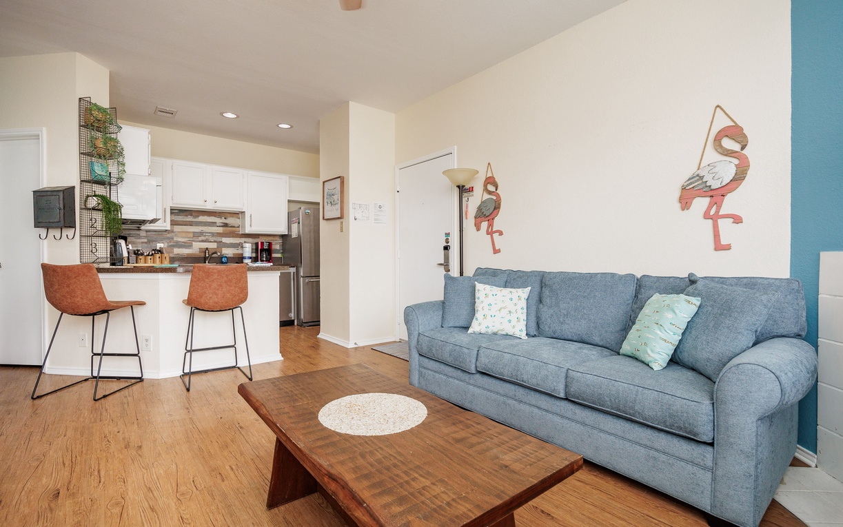 Relax in this stylish open-concept living space with plush seating and a fully equipped kitchen for your comfort.
