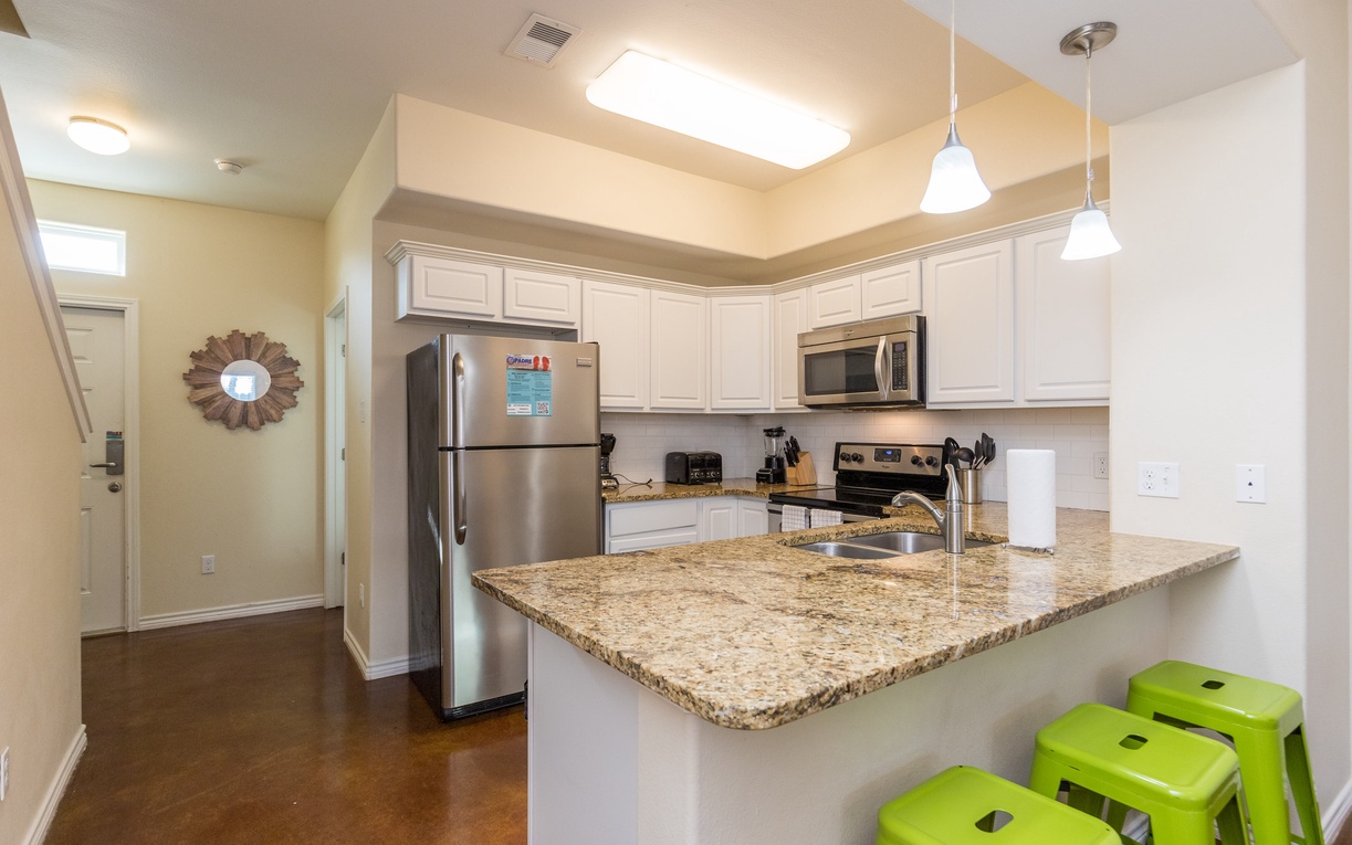 Cook up your favorite meals in this bright, modern kitchen featuring granite counters, stainless appliances, and cheerful breakfast bar seating.