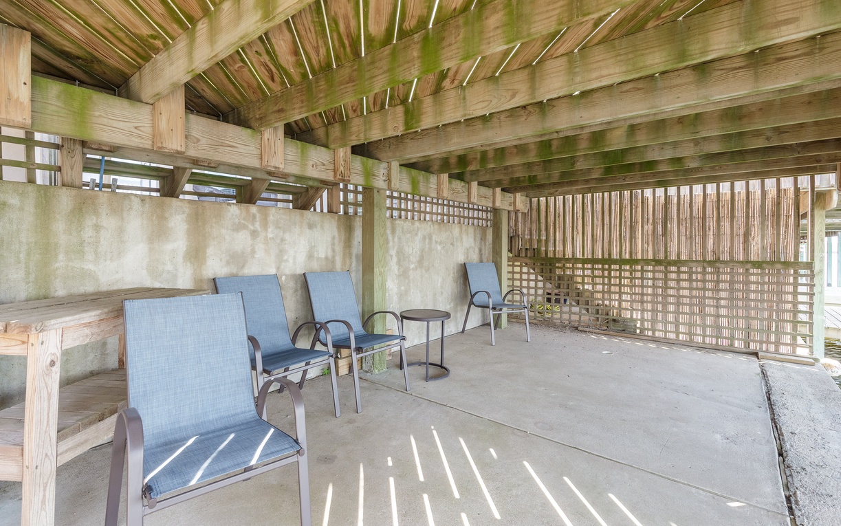 Relax in your private covered patio where filtered sunlight creates beautiful patterns while you unwind in comfortable seating.