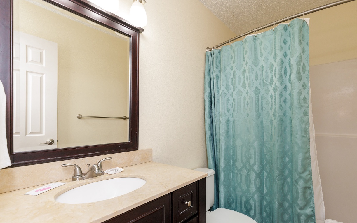 Step into your private bathroom featuring a spacious vanity and refreshing shower area for your comfort and convenience.