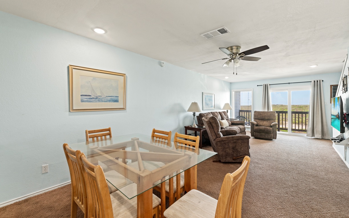Relax in your open living and dining space where you'll find comfortable seating, a welcoming atmosphere, and genuine natural views through the balcony doors. Gather for meals or unwind while taking in the peaceful scenery beyond.