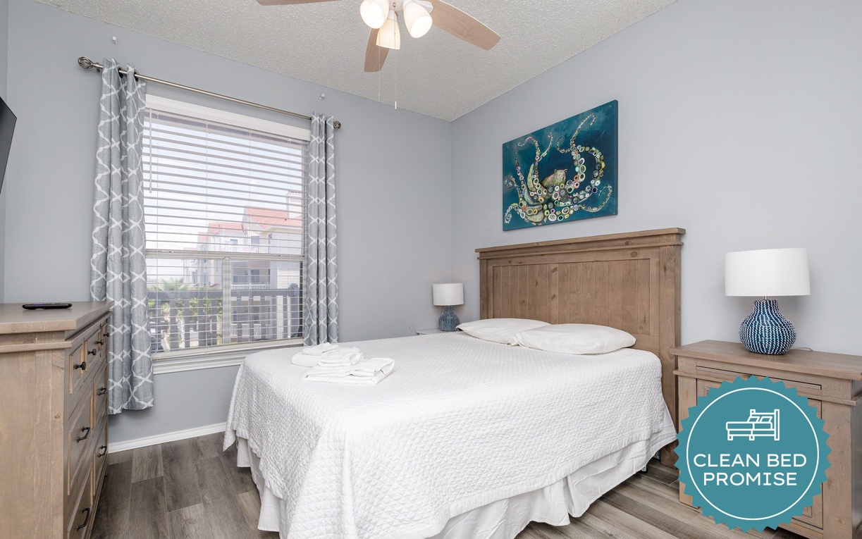 Your serene bedroom features comfortable bedding, coastal artwork, and city views to help you unwind after exploring.