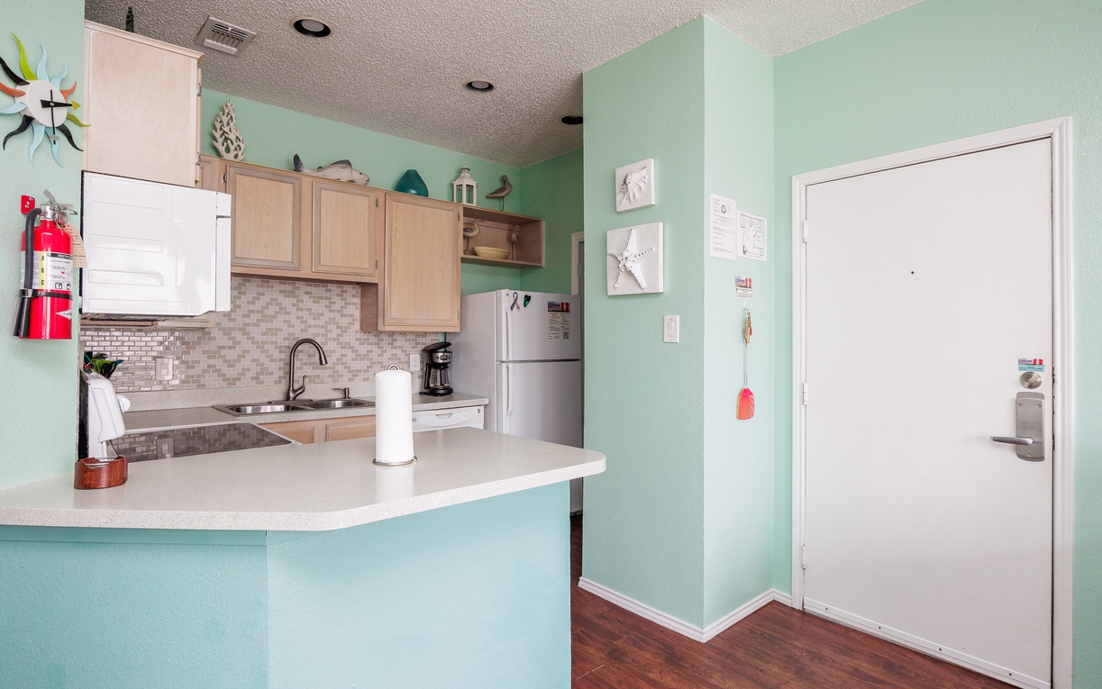 Unwind in your modern kitchen featuring mint walls, granite counters, and everything you need to whip up delicious vacation meals.