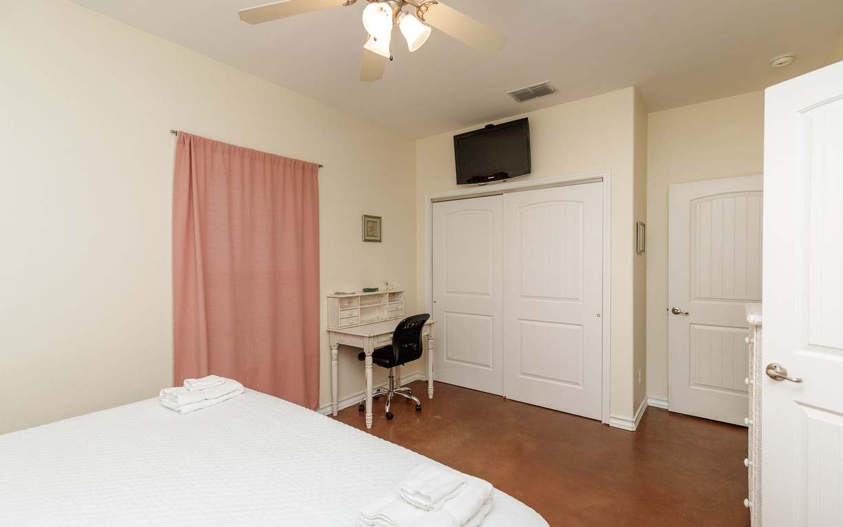 Your peaceful bedroom features a comfortable bed, desk workspace, and flat-screen TV for relaxation after exploring the area.