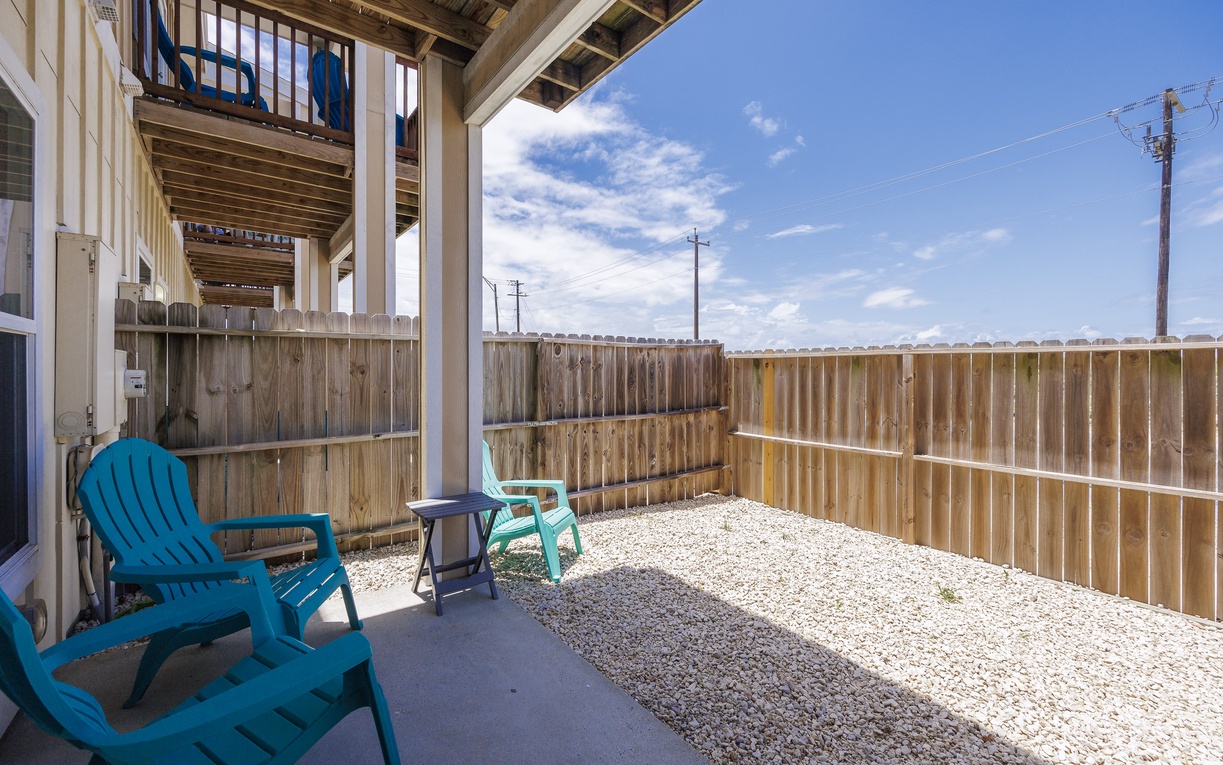 Step onto your private patio where colorful Adirondack chairs await, perfect for morning coffee or evening relaxation in your fenced outdoor sanctuary.