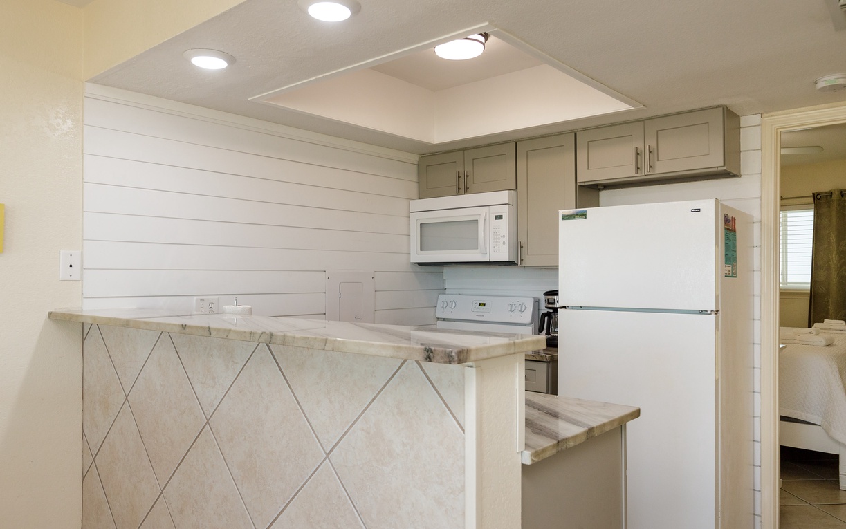 Cook with ease in your fully equipped kitchen featuring modern appliances, ample counter space, and charming coastal-inspired design.