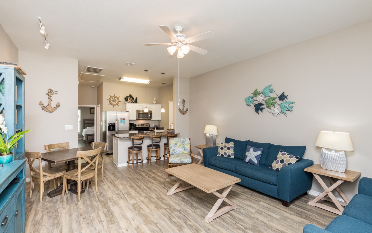 Unwind in your coastal-themed living space with comfortable seating and an open kitchen perfect for gathering.
