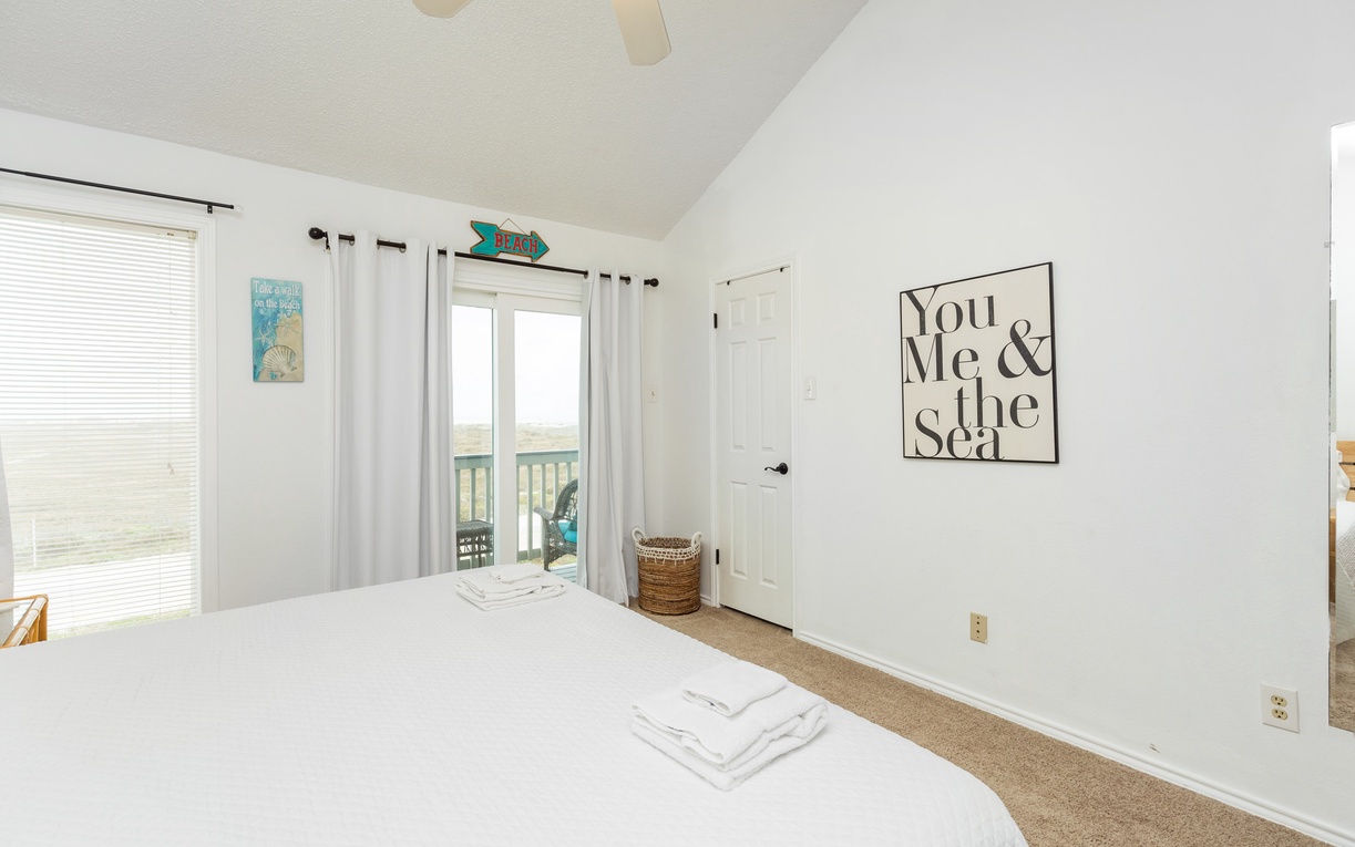 Wake up in your serene bedroom where ocean views greet you through sliding doors. Fresh linens and coastal charm create the perfect retreat.