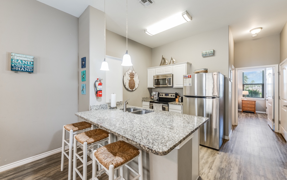 Cook up your perfect beach getaway in this fully-equipped kitchen with granite countertops, stainless steel appliances, and a breakfast bar for casual dining.