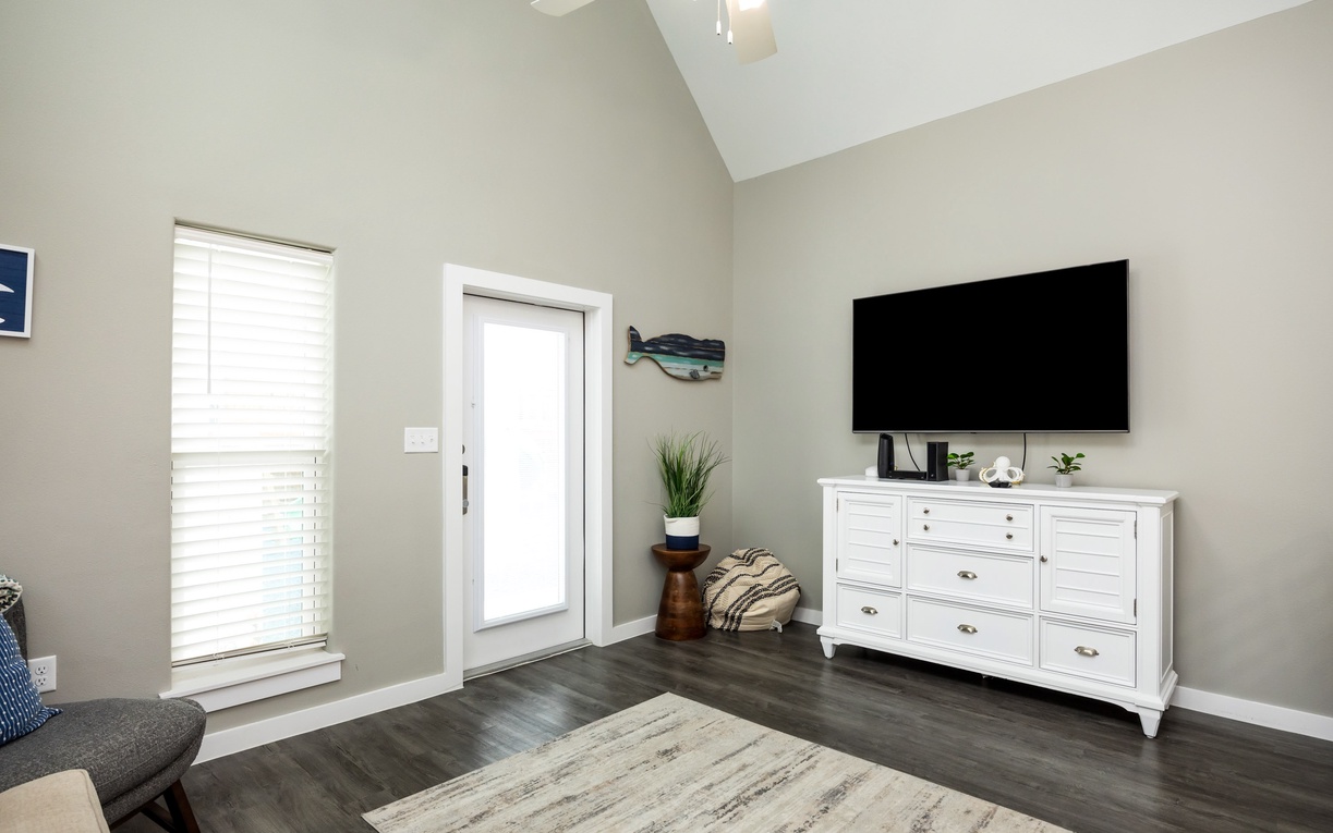 Relax in your stylish living space with vaulted ceilings, modern furnishings, and coastal touches that create the perfect retreat atmosphere.
