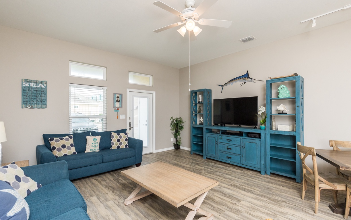 Sink into comfortable coastal vibes with your sectional sofa and large TV. Nautical touches create perfect beach house charm.