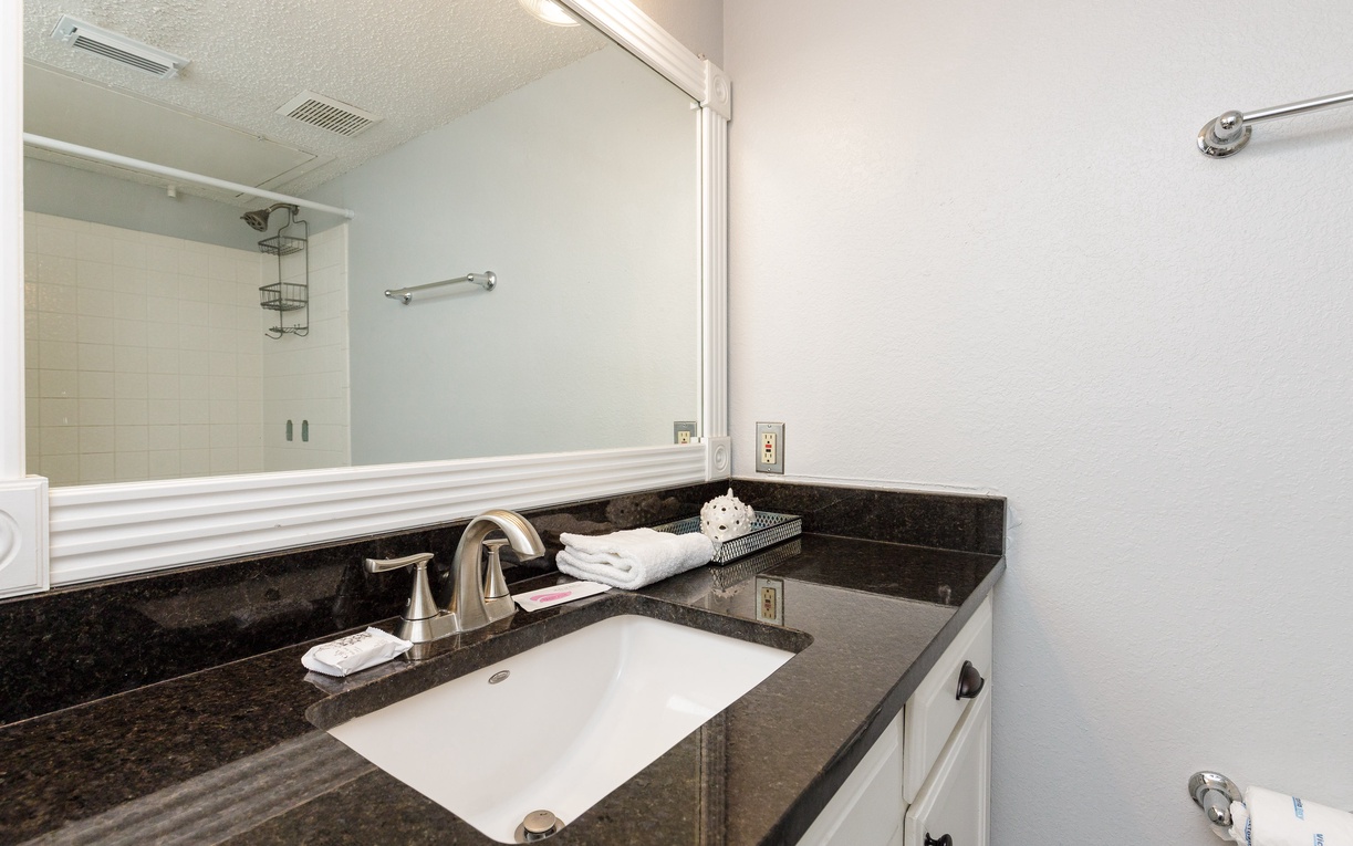 Step into your pristine bathroom with elegant granite counters and fresh towels waiting for your arrival.