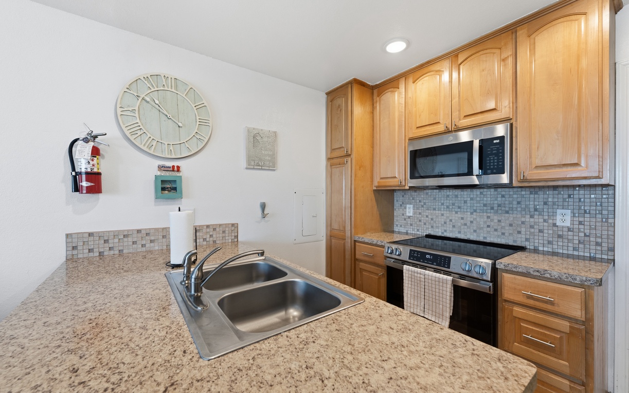 Cook to your heart's content in this fully equipped kitchen with sleek countertops, stainless steel appliances, and plenty of storage in warm wood cabinetry.