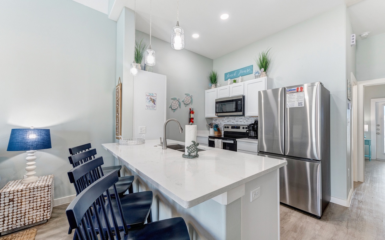 Your modern kitchen features stainless steel appliances, quartz countertops, and pendant lighting perfect for cooking memorable vacation meals together.