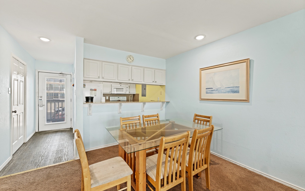 Gather around this inviting dining table where you can share meals and make memories together. The open layout connects seamlessly to your kitchen, making every meal feel effortless and relaxed.
