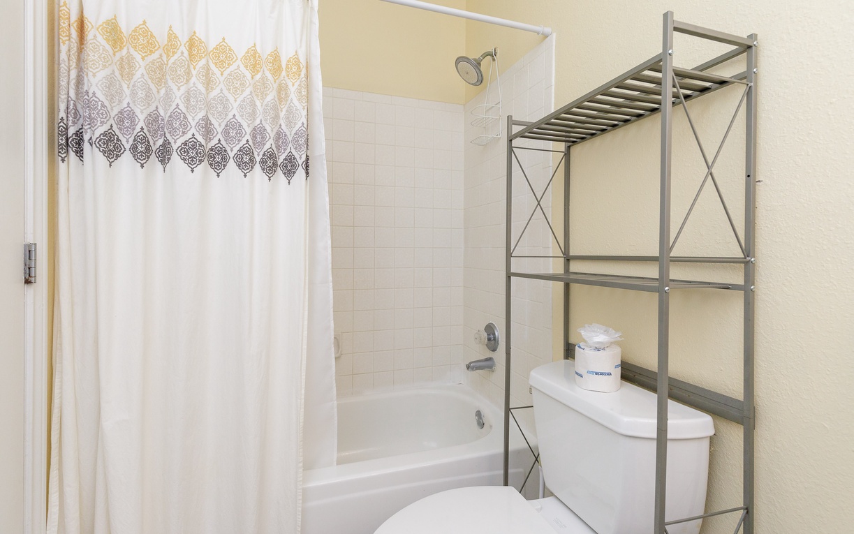 Your private bathroom features a relaxing tub-shower combo and thoughtful storage rack, making it easy to settle in and feel at home.