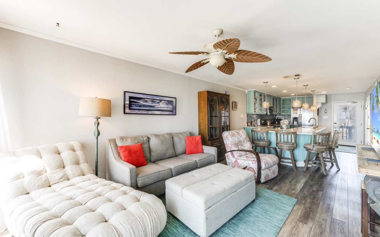 Unwind in your spacious open-concept retreat with tropical ceiling fans, plush seating, and turquoise accents that bring coastal charm indoors.