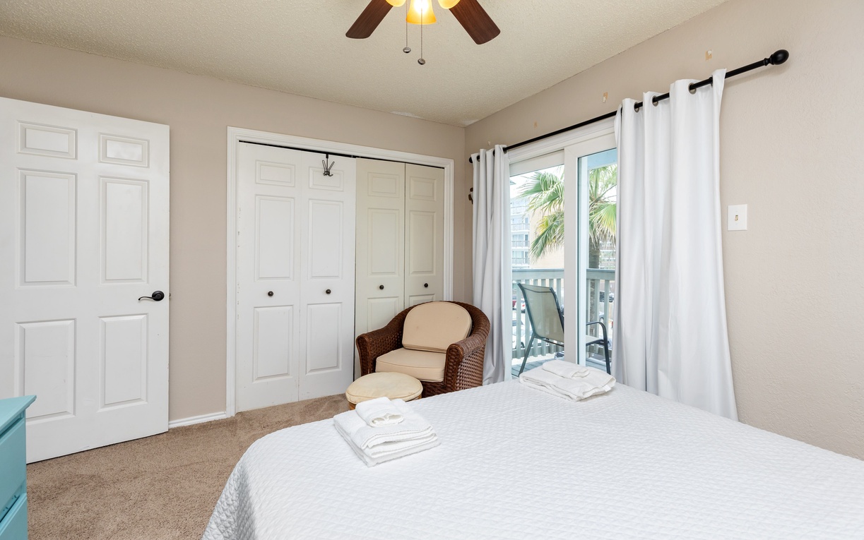 Your peaceful bedroom retreat features crisp linens, a cozy reading chair, and balcony access to tropical views.