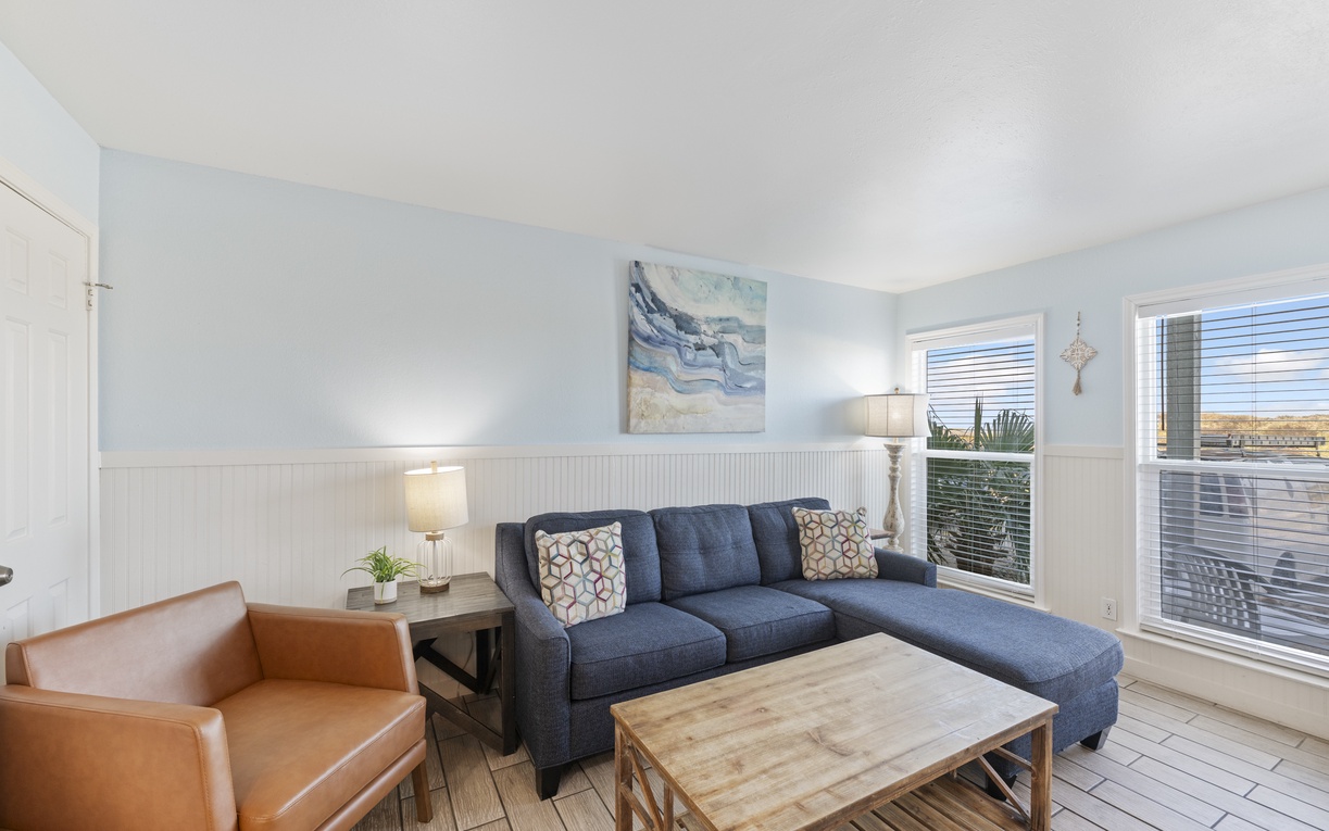 Sink into the plush navy sectional and unwind in your bright, coastal-inspired living space with charming beadboard details and ocean artwork.