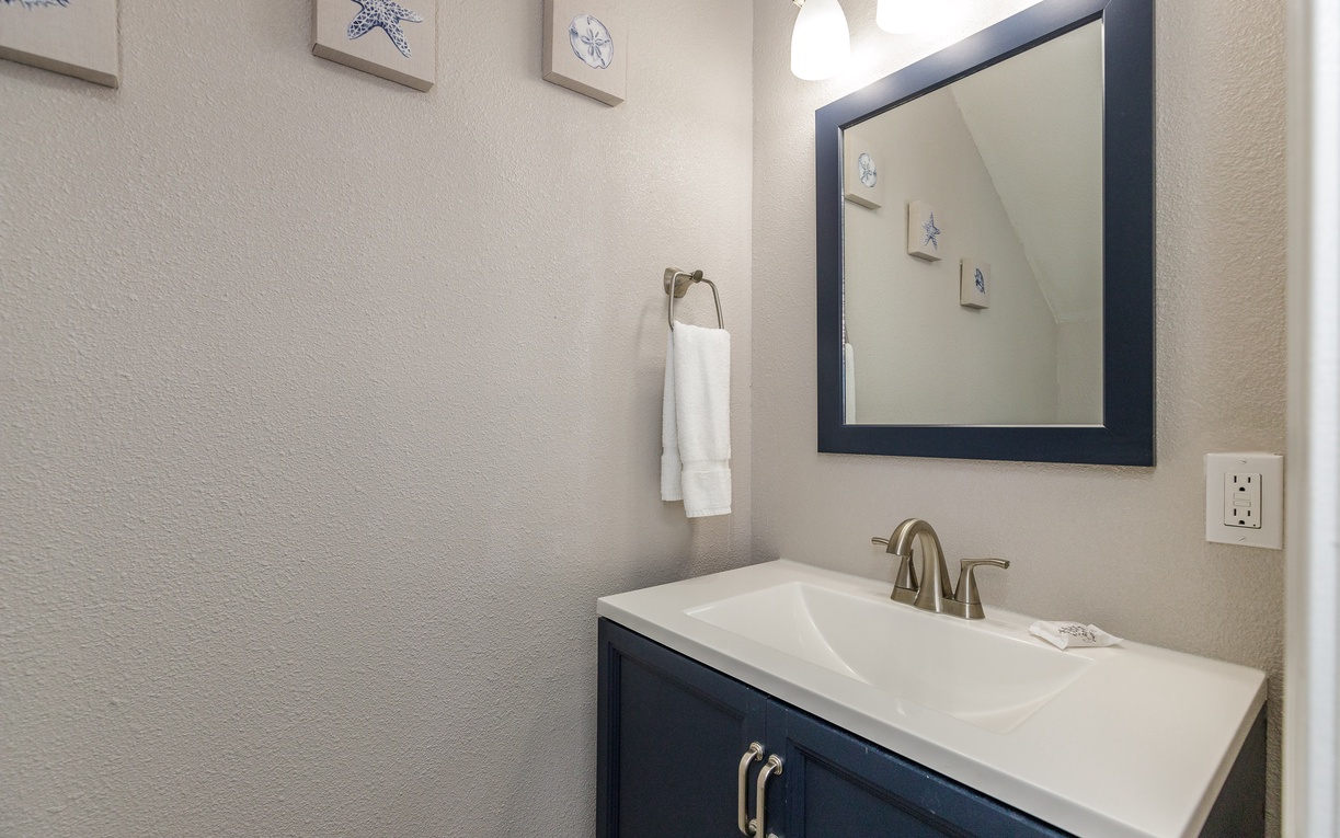 Your bright powder room features coastal charm with starfish art and fresh towels ready for your stay.