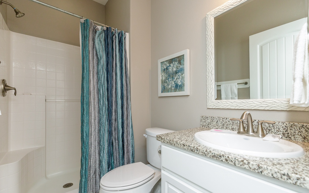 Step into your private retreat with granite countertops, rainfall shower, and coastal-inspired décor that creates the perfect sanctuary.