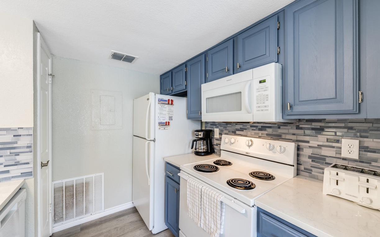 Your fully-equipped kitchen features stylish blue cabinets, modern appliances, and everything you need to prepare delicious meals during your stay.