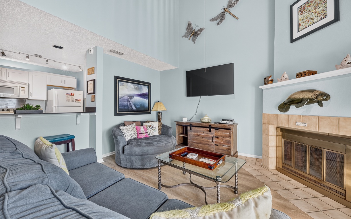 Sink into plush sofas in your bright, coastal-inspired living space, where a cozy fireplace and eclectic beach décor set the scene for memorable evenings together.