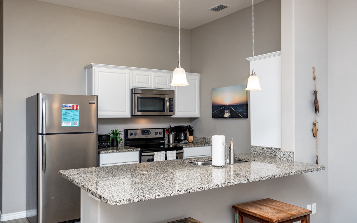 Your modern kitchen features granite countertops, stainless steel appliances, and pendant lighting—perfect for preparing meals during your stay.