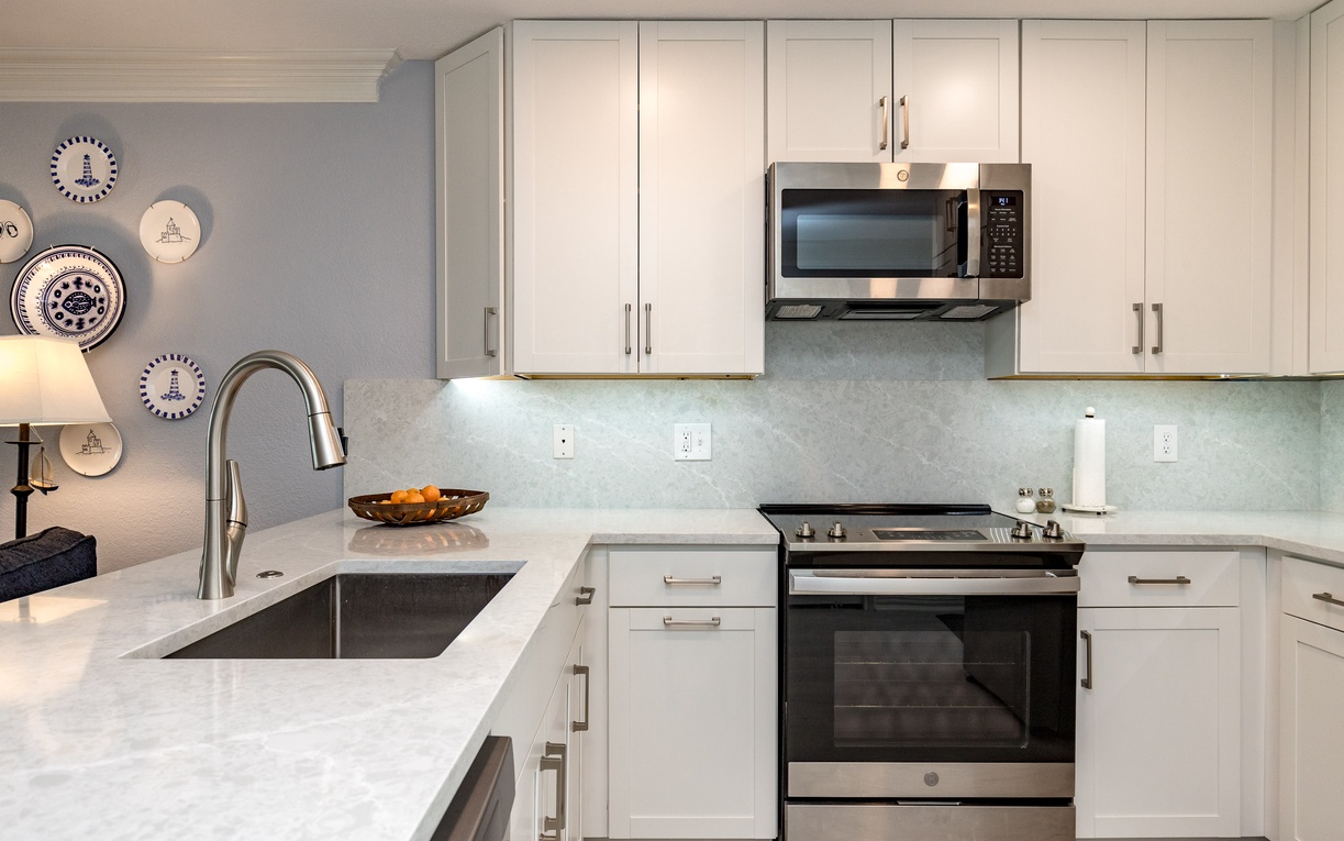 Your modern kitchen features sleek white cabinets, granite counters, and stainless appliances - perfect for preparing meals during your stay.