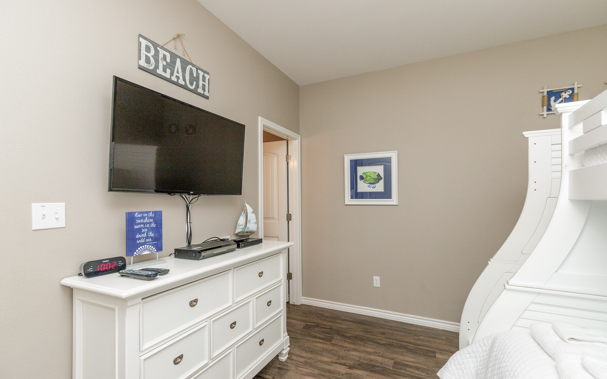 Cozy up in your beach-themed bedroom with a flat-screen TV, coastal decor, and comfy bunk beds perfect for family getaways.